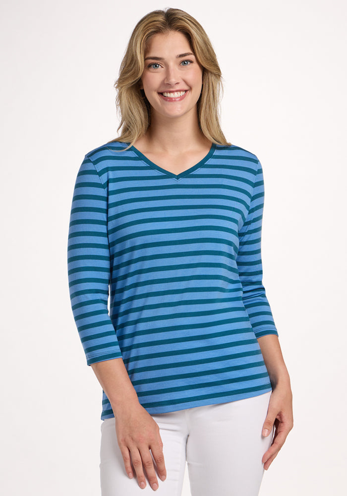Woman smiling in the Woolx Elena 3/4 Sleeve V Neck - Coastal Stripe, paired with white pants. | Ariana is 5'11", wearing a size S