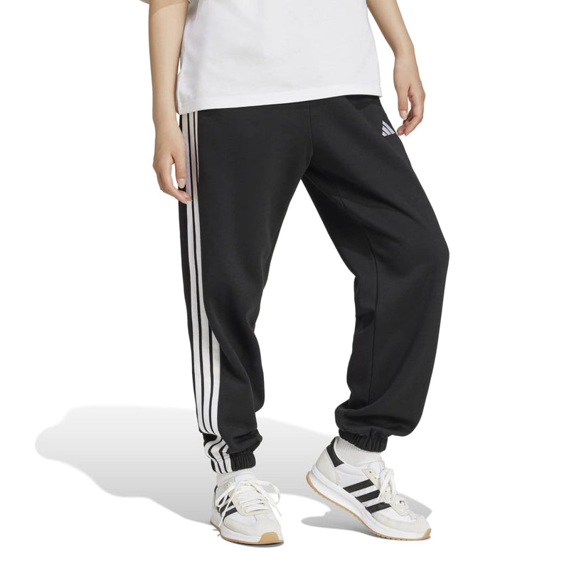 Women’s black loose track pants with vertical white stripes and ribbed ankle cuffs.