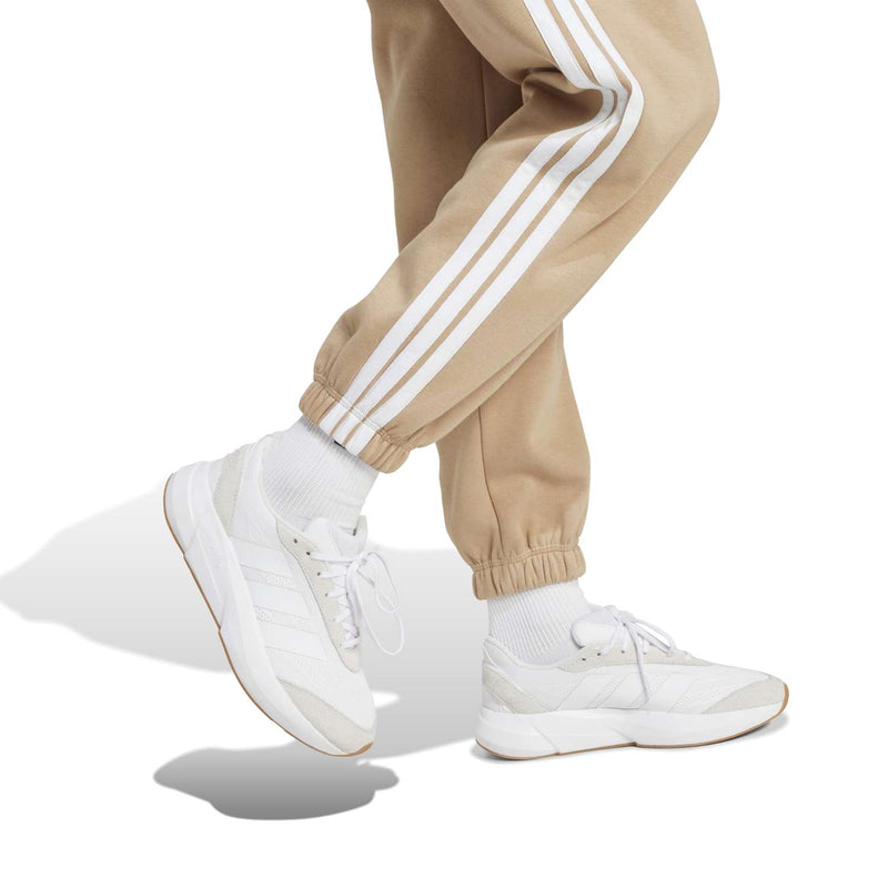Warm sandstone jogger pants with white three-stripe side details and elastic ankle cuffs