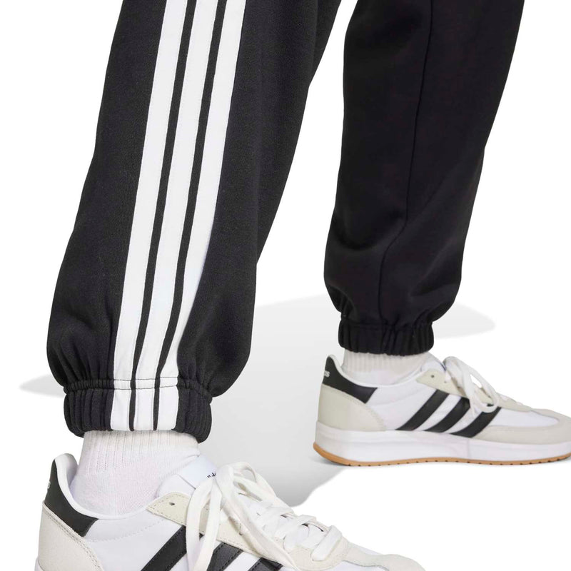 Women’s black track pants with white 3-stripe panels and ribbed ankle cuffs.