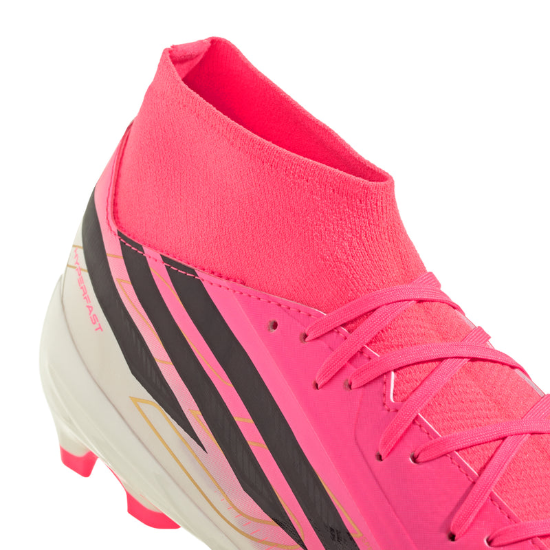 Close-up of men's mid soccer cleat with pink upper, orange collar, and black-striped side