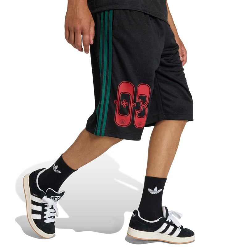 Men's black shorts side view with green triple stripe and red 83 patch on the thigh