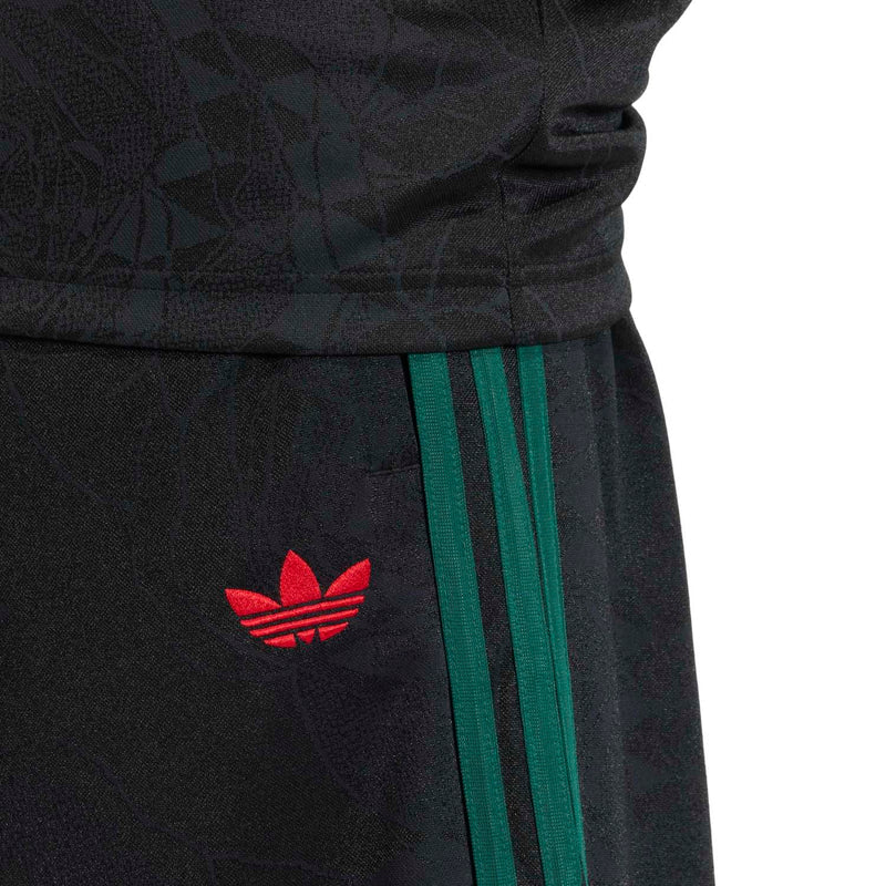 Men's black shorts close-up of red adidas-style logo with green triple stripe