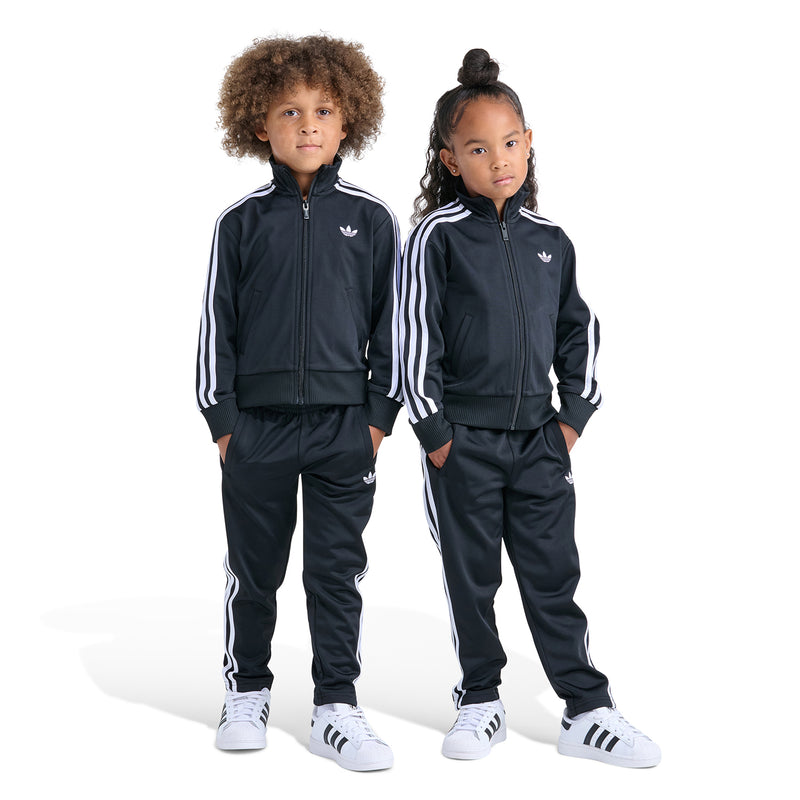 Kids track set on two models: zip-up jacket and pants in black with white stripes.