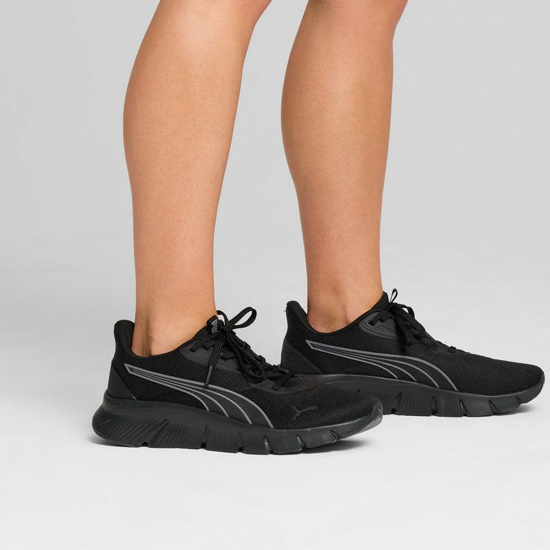 Men's black lace-up running shoes on feet with thick textured tread sole