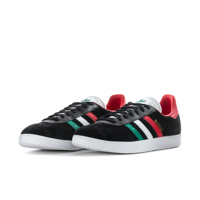 Black men's sneakers with white triple stripes, green accent stripe, red collar, white sole