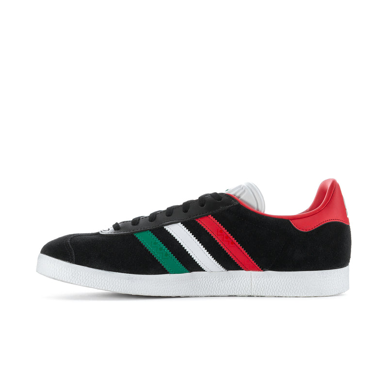 Black low-top men's sneakers with white stripe bands, red center stripe, green accent