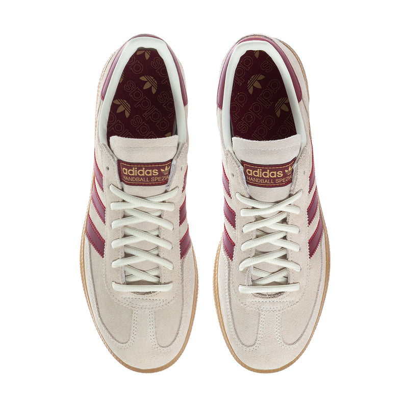 Beige low-top sneakers with burgundy stripes, lace-up front, and suede finish