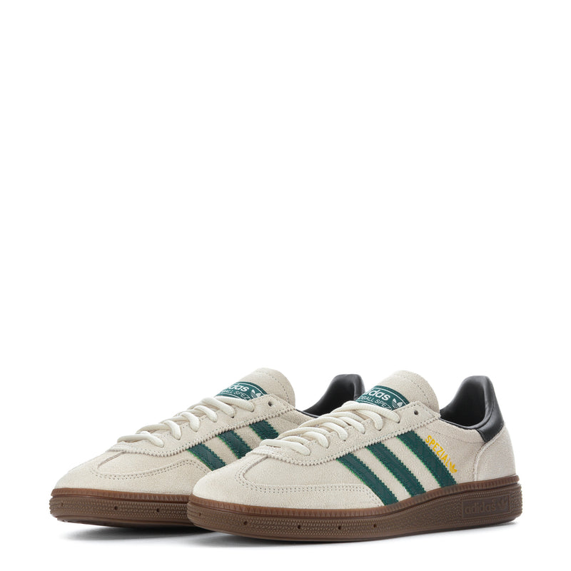 Youth sneakers pair, off-white uppers with green stripes and dark heel panels