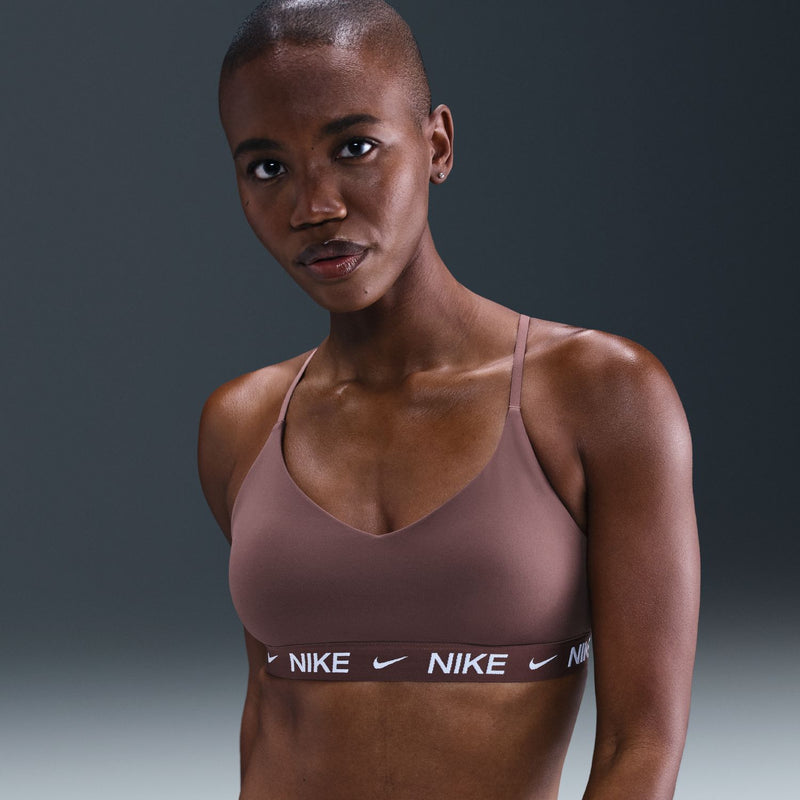 Mauve women's sports bra with V-neck, thin straps, and Nike logo band