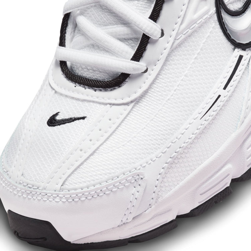 Close-up of white Nike Initiator sneaker upper with black swoosh and lace detail.