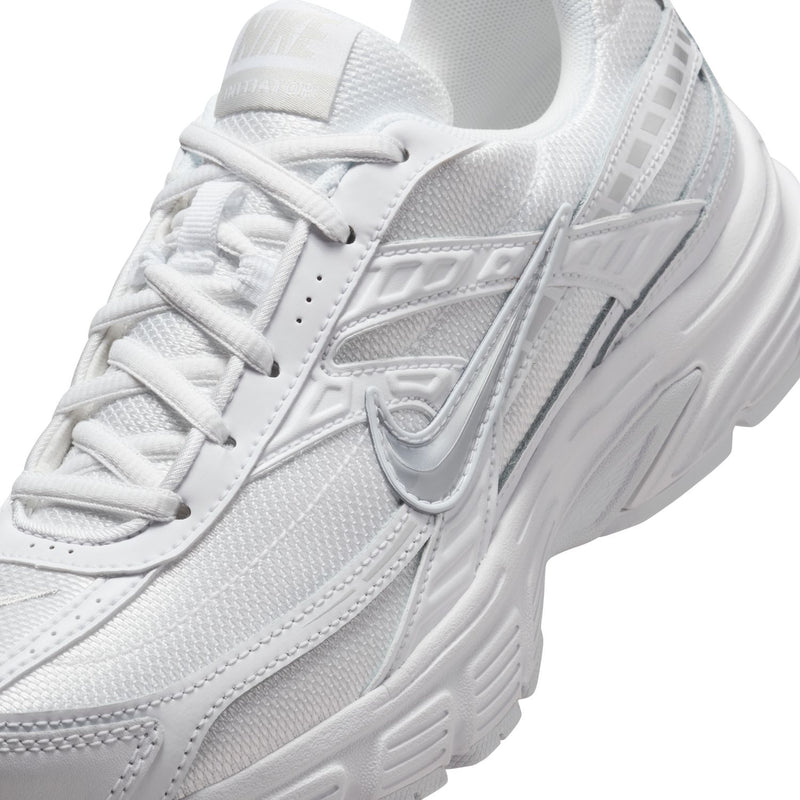 White women's sneaker close-up of laces, mesh texture, and Swoosh detail