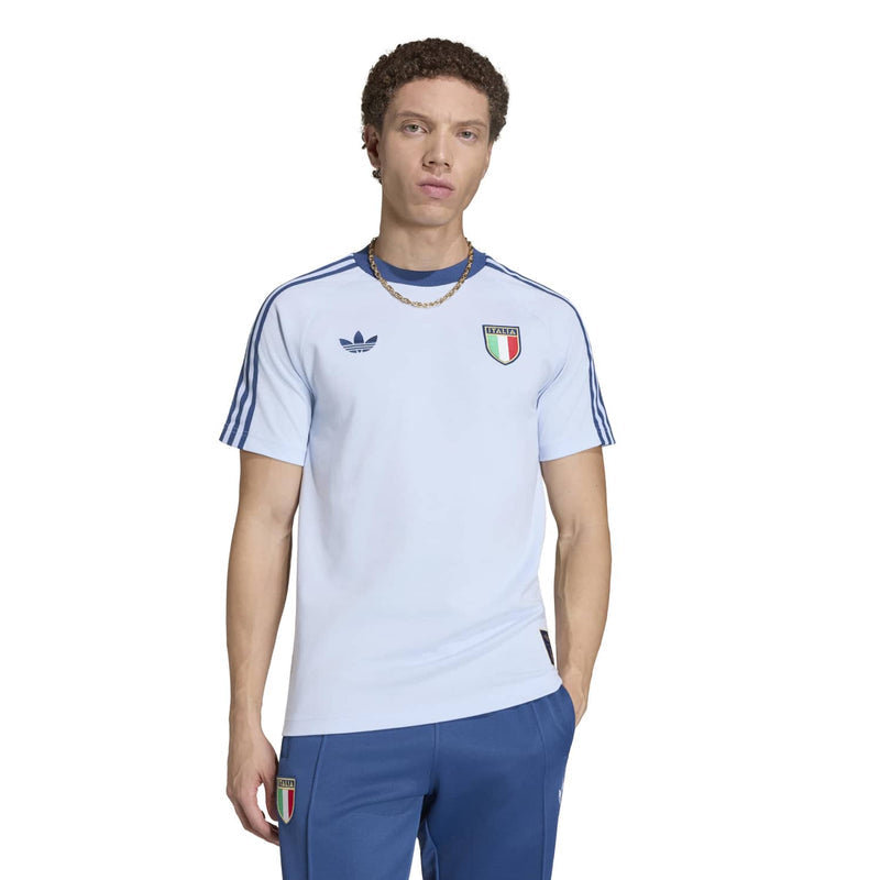Light blue men’s crewneck T-shirt with Italy crest on chest; worn with blue pants