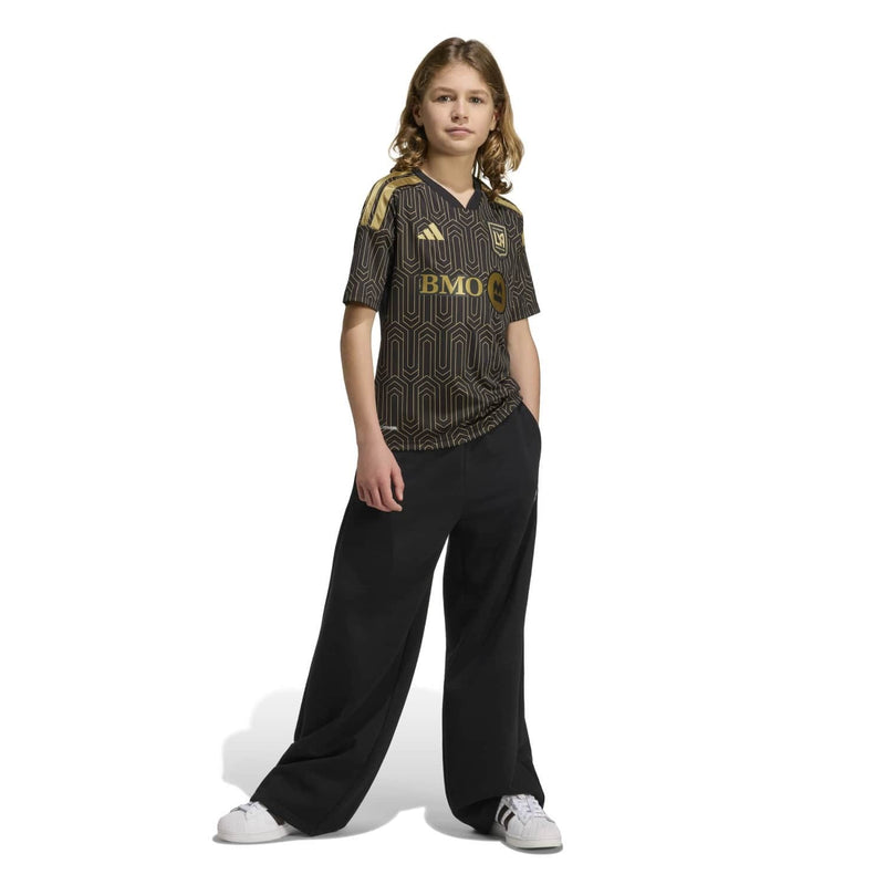 Youth black soccer jersey with gold geometric print, short sleeves