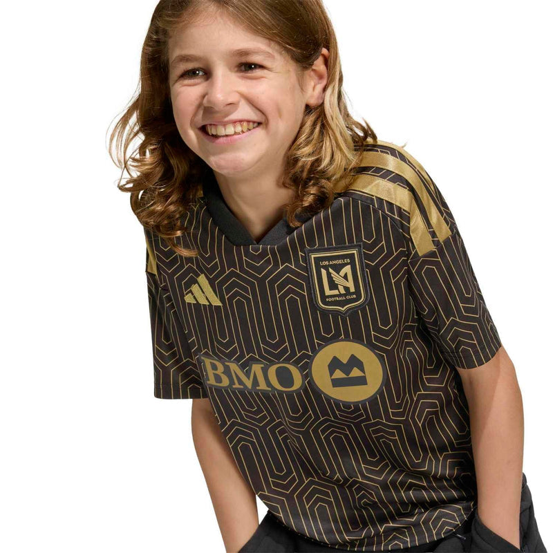 Youth black soccer jersey close-up with gold geometric pattern, BMO logo, and LAFC crest