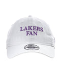 White baseball cap with purple “LAKERS FAN” front text and curved brim