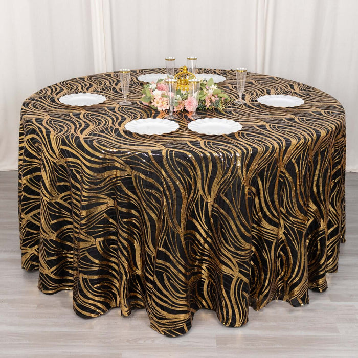 Elegant black and gold wave-patterned tablecloth on a round table with decorative accents.