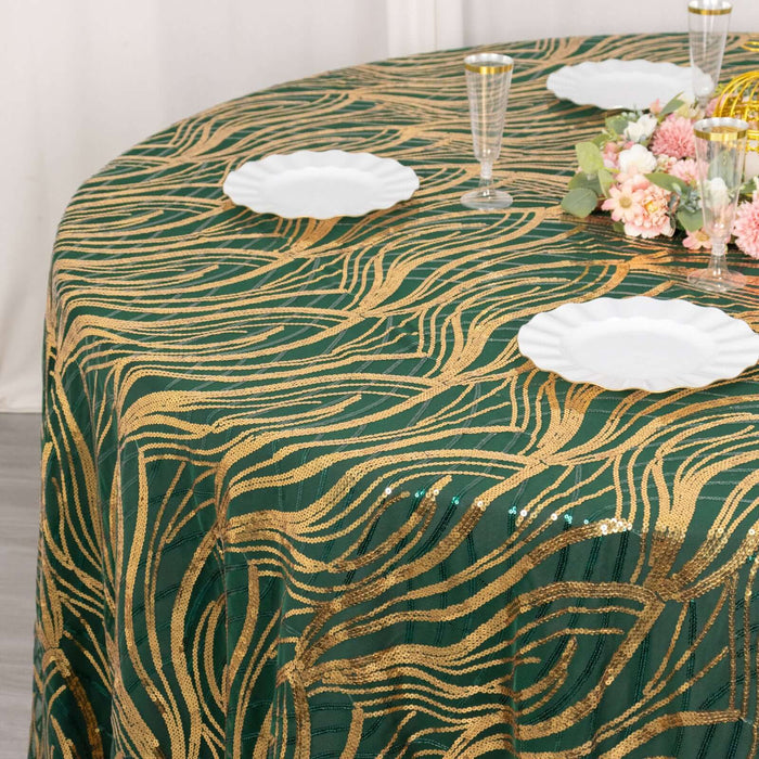 Green and gold patterned tablecloth with plates and floral centerpiece