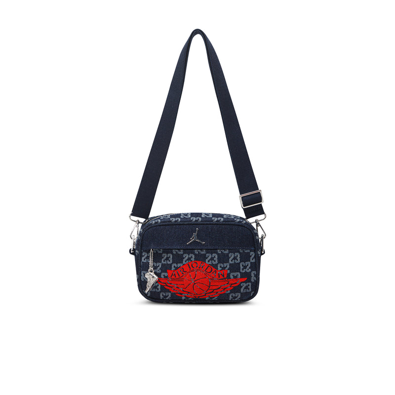 Dark indigo crossbody camera bag with adjustable strap and red logo graphic