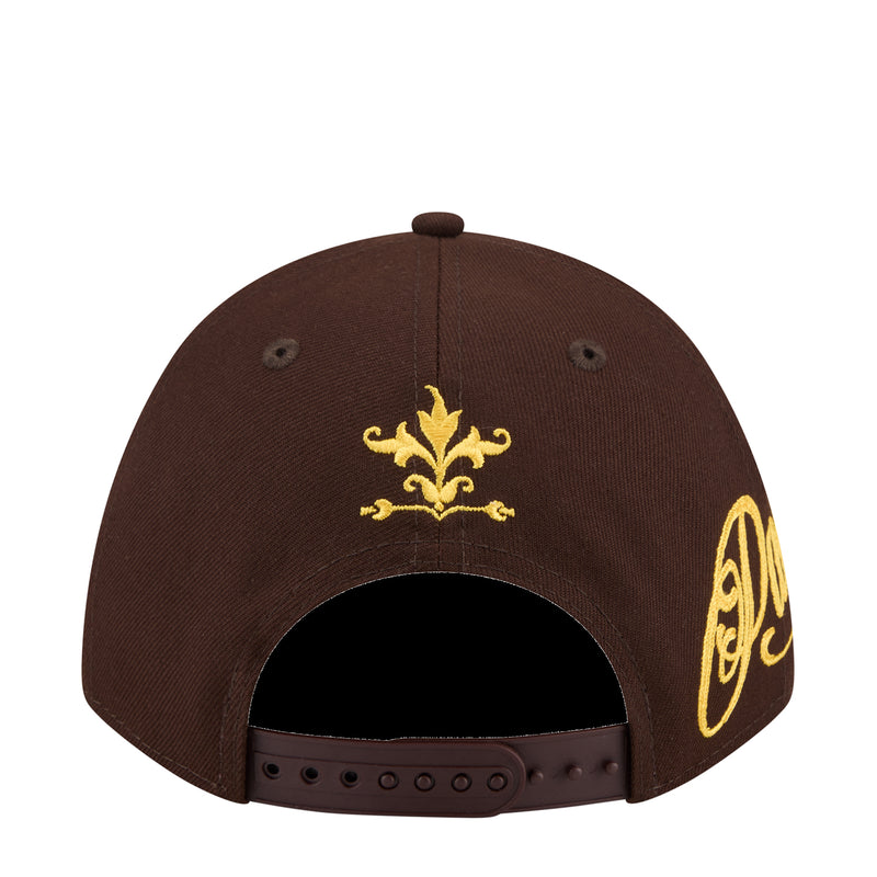 Brown baseball cap with gold fleur-de-lis emblem on front and partial wordmark