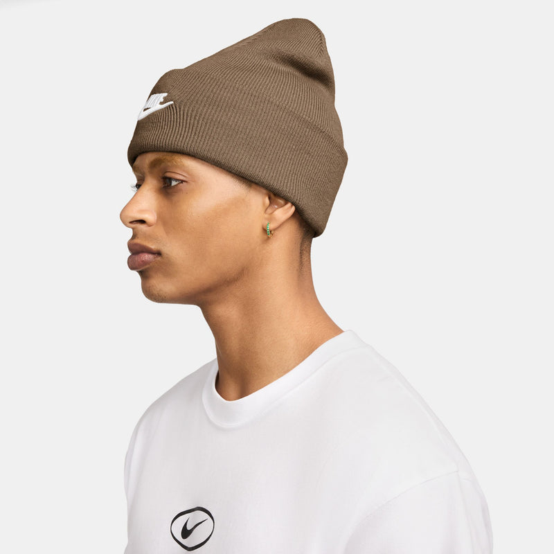 Brown knit beanie with folded cuff, side view with small white Nike logo