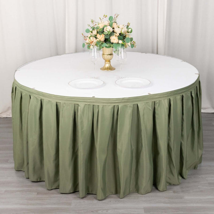 Round table with olive green skirt and floral centerpiece.