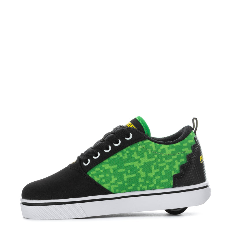 Youth black sneaker with green upper panel, black laces, and pixel graphics
