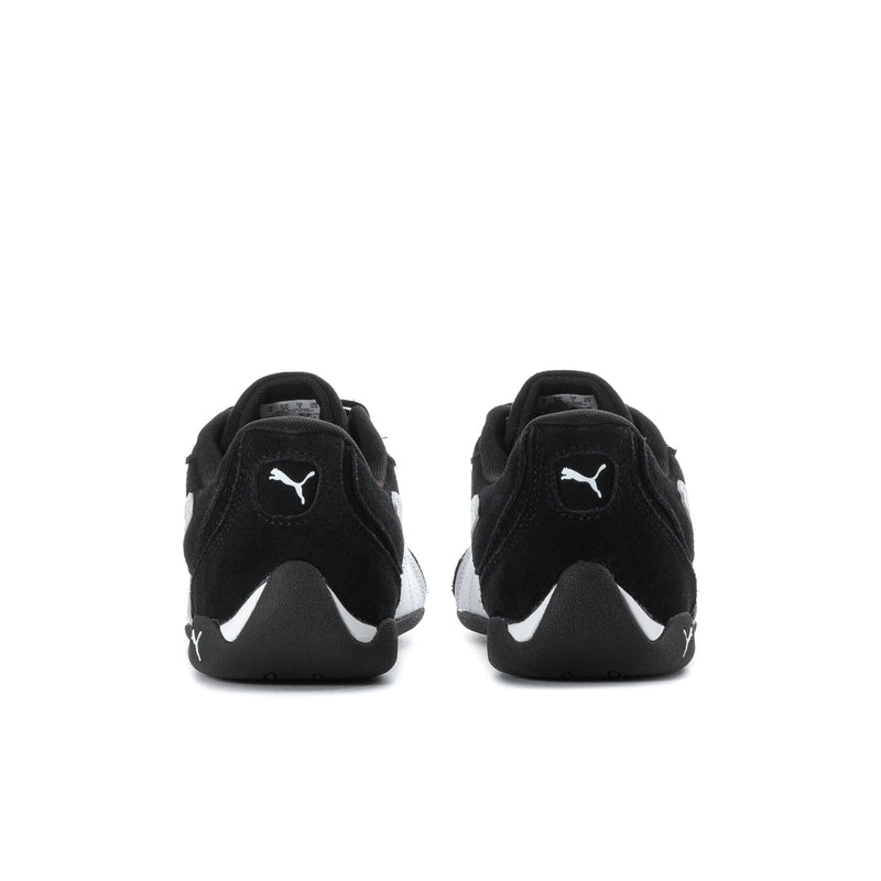 Black low-top sneakers from heel view, white sole trim and PUMA logo.