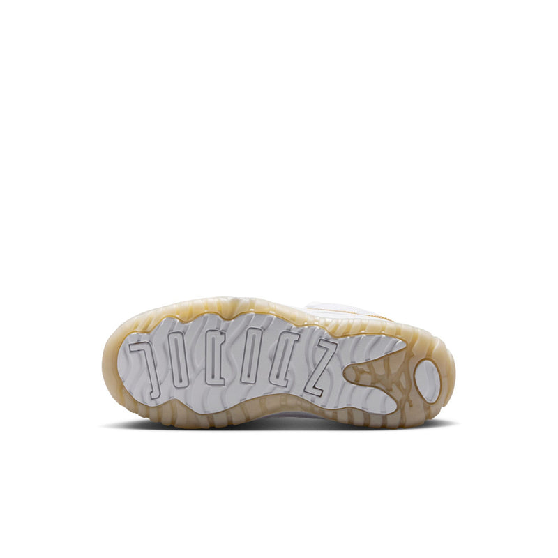 Kids sneaker outsole view with textured tread and white-and-gold rubber