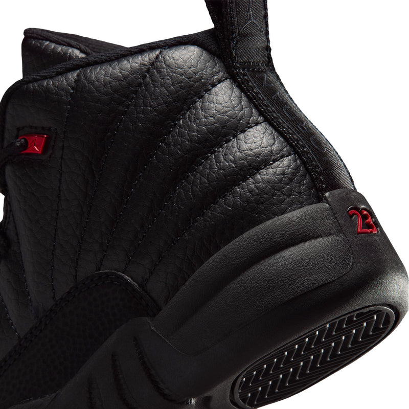 Kids black high-top sneaker close-up: side panel leather texture and red eyelet accents