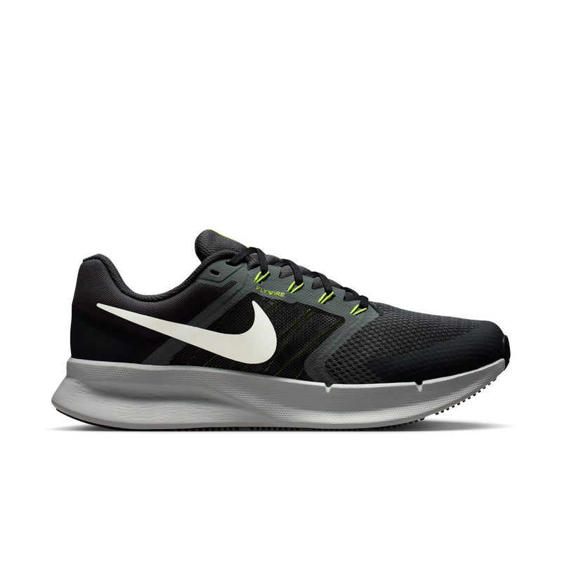 Men's black running shoes with white swoosh and neon green lace accents