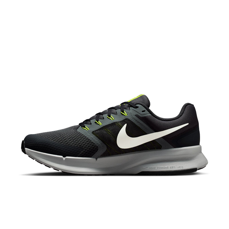 Men's black running shoes with white swoosh, neon green eyelets, and gray sole