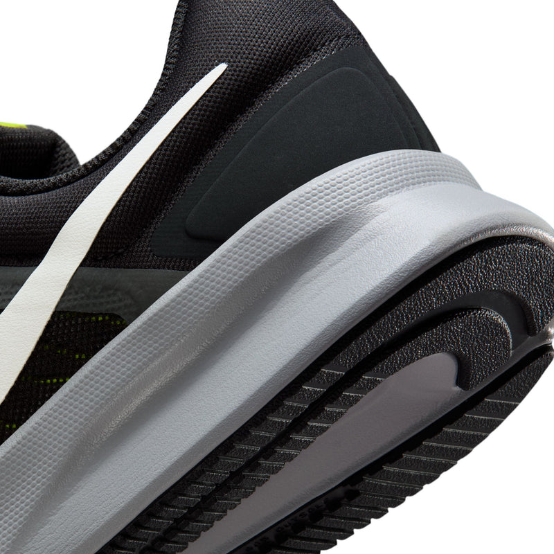Side close-up of men's black running shoe with white midsole and neon green accents