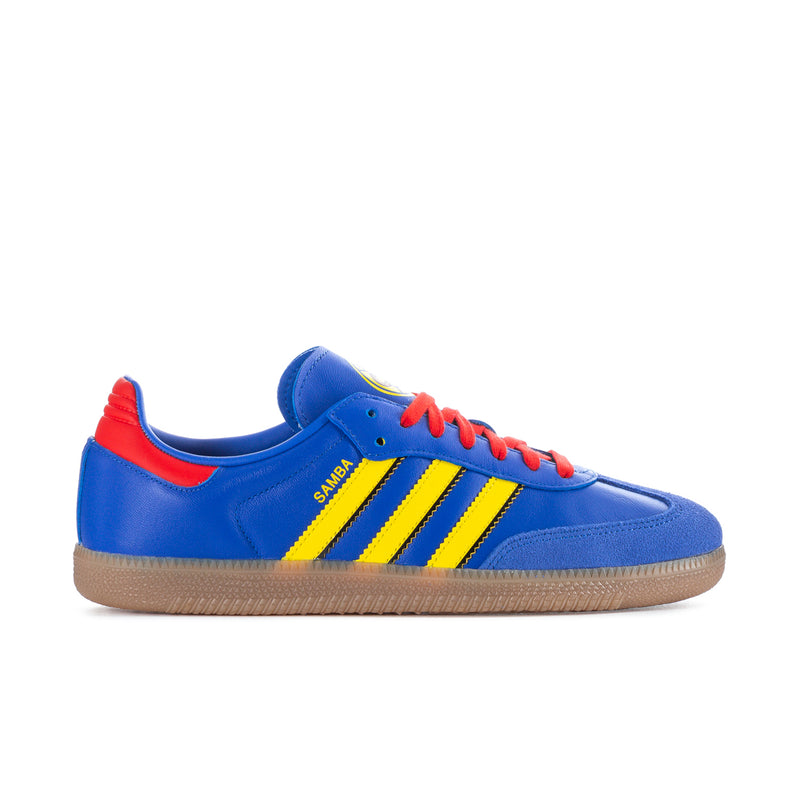 Men's blue low-top sneakers with yellow triple stripes, red laces, gum sole