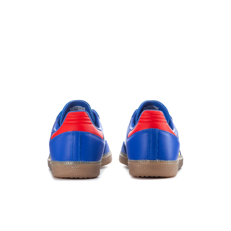 Men's blue sneakers with red heel trim, yellow stripe detail and gum outsole