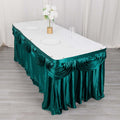 Teal table skirt with elegant draping for events and parties.