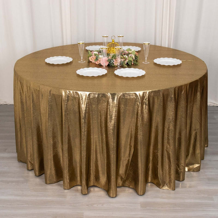 Gold sequin tablecloth draping over a round table with elegant dinnerware and decor.