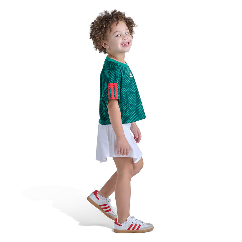 Kids green soccer skort set, angled side view: adidas tee with white skort