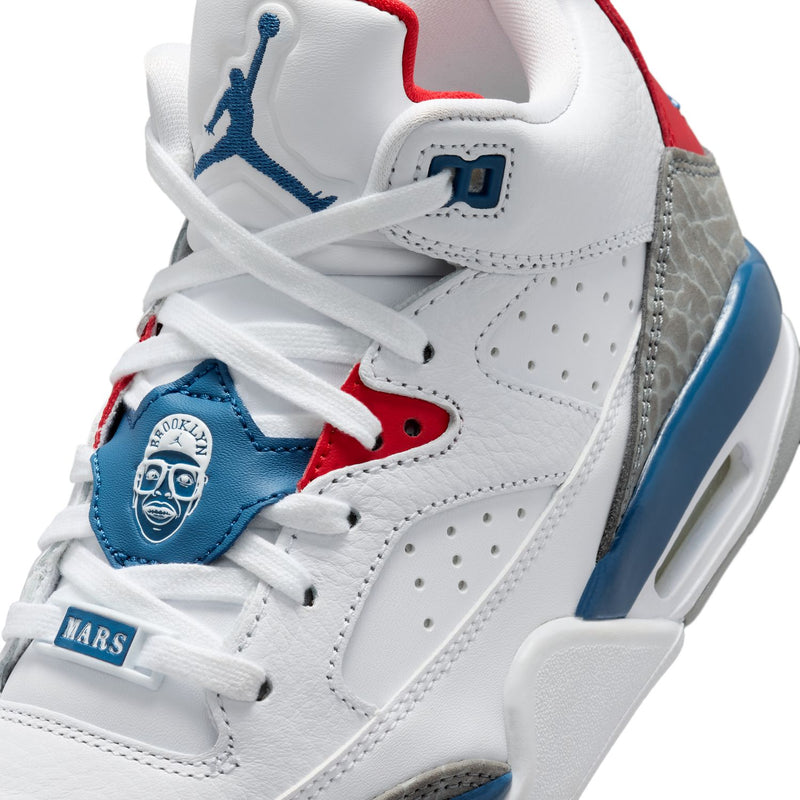 Close-up of youth sneaker upper with blue patch, white laces, red tongue trim, and stitching
