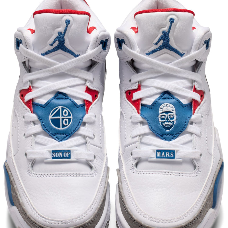 Youth sneakers front view with white laces, blue patch details, and red heel accents