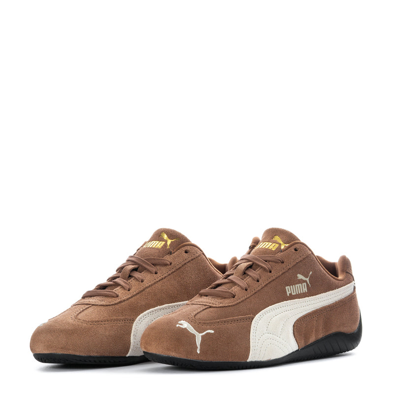 Pair of brown suede sneakers with white PUMA stripe and black rubber sole