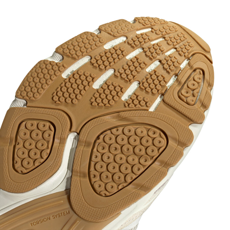Close-up of women's sneaker outsole with tan traction dots and rubber tread segments