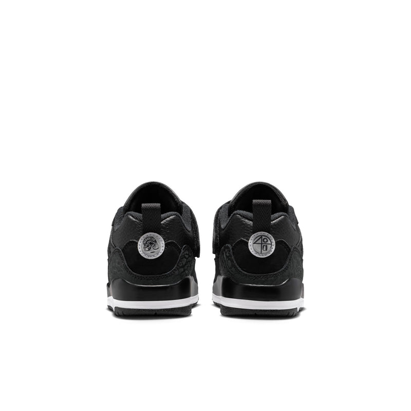 Kids black low-top sneakers with heel tab, circular back logo patch, white midsole