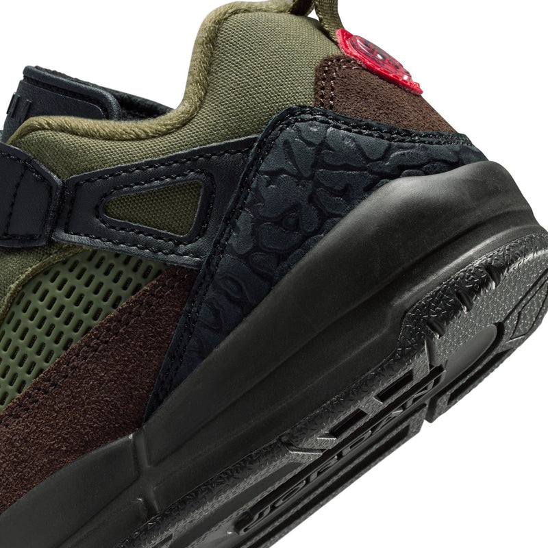 Kids sneaker close-up of side: textured black panels, olive mesh, brown suede, red stitch