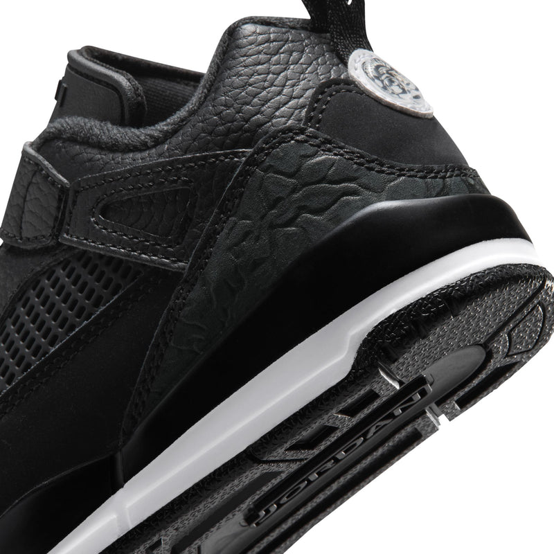 Kids black sneaker close-up with textured side panel, side logo, white midsole