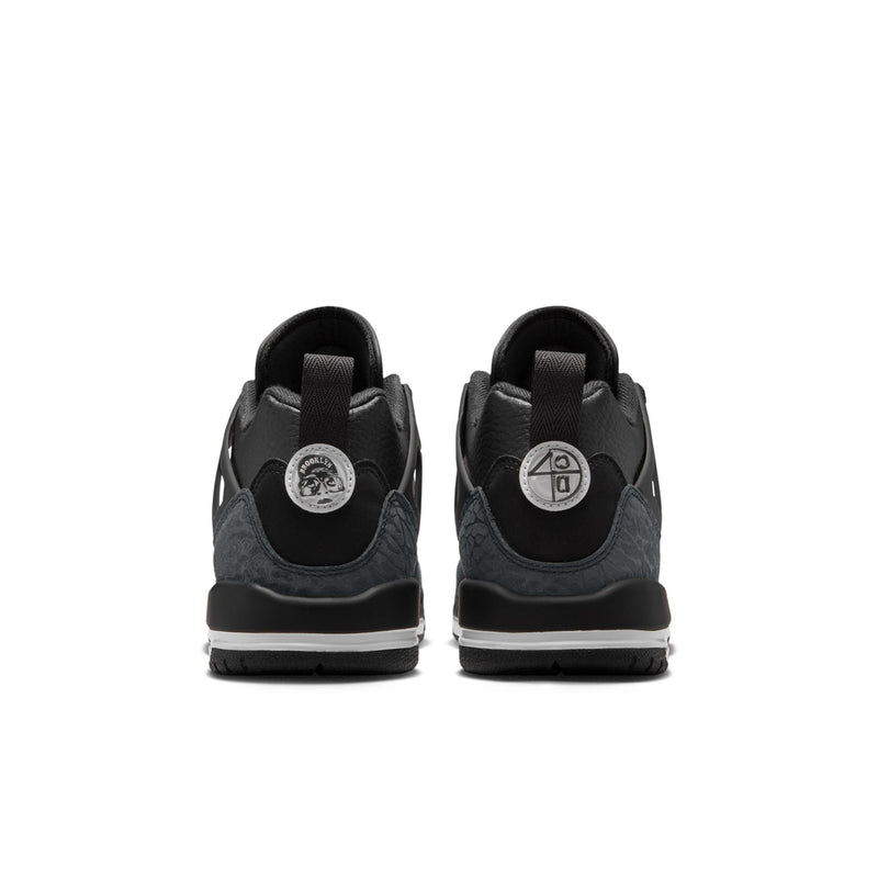Youth black low-top sneakers showing padded heel tabs and rear branding patches