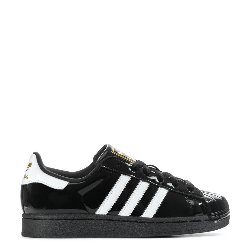 Women’s black patent leather sneaker with white three-stripe sidewall and black laces