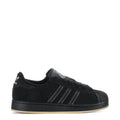 Youth black low-top sneakers with three-striped design and lace-up closure.