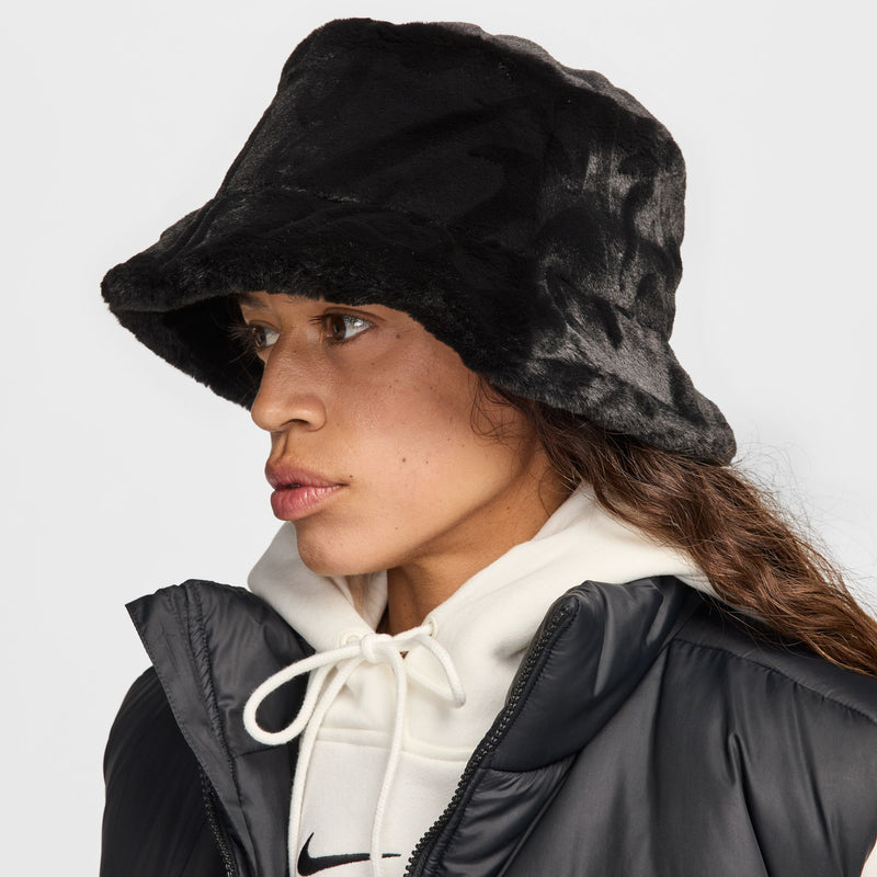 Black faux fur bucket hat worn with a hooded jacket, side profile