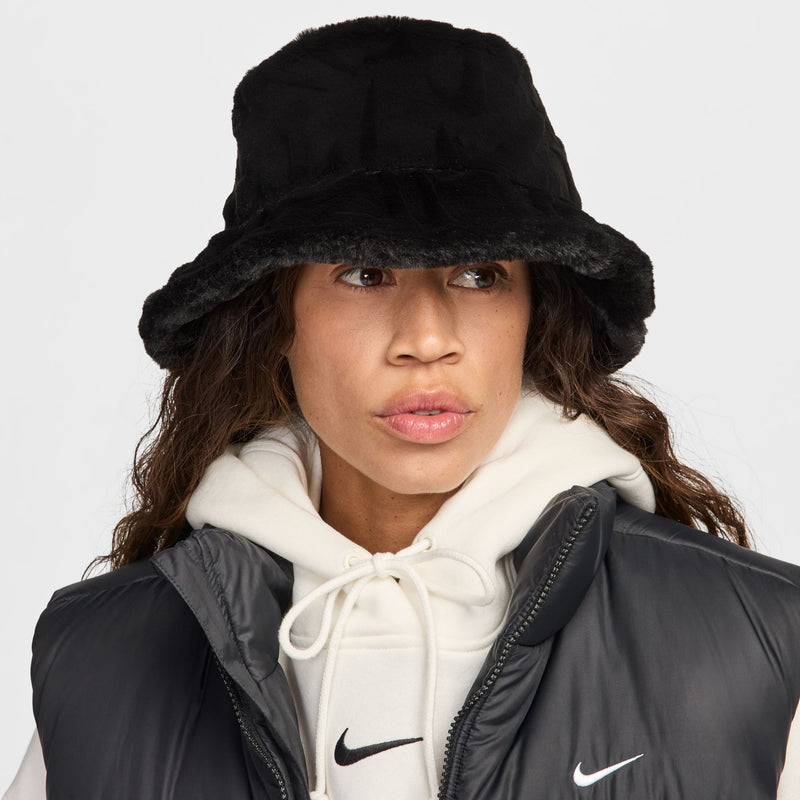 Black faux fur bucket hat worn with a white hoodie and black puffer vest